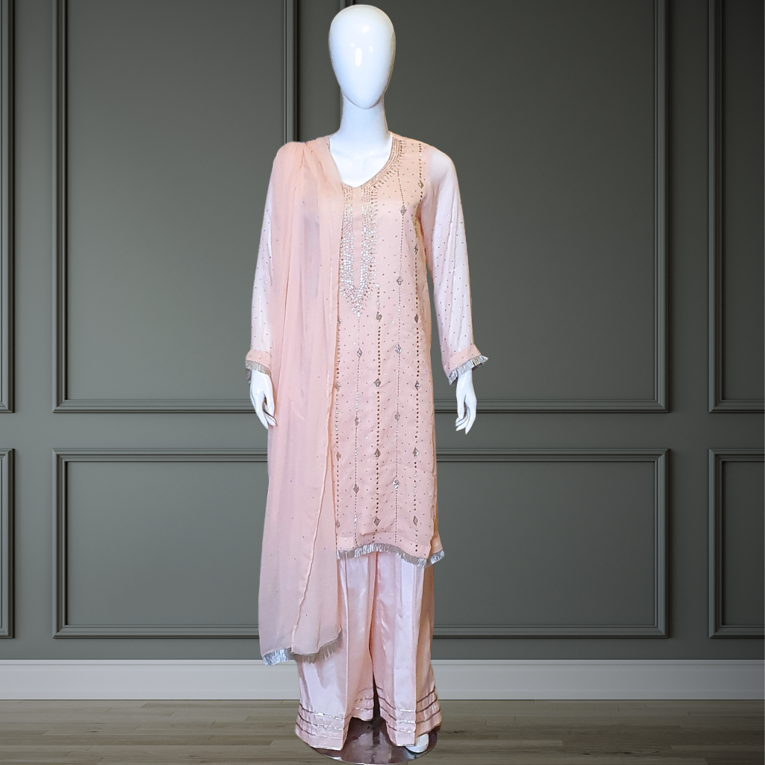 Peach Classic Mukesh Outfit - 3PC. Features intricate gold and silver embroidery on the neckline, soft chiffon shirt, silk Plazzo with gota details, and finished dupatta with Mukesh and lace. Sleeves also adorned for a cohesive look. Perfect for any festive occasion.