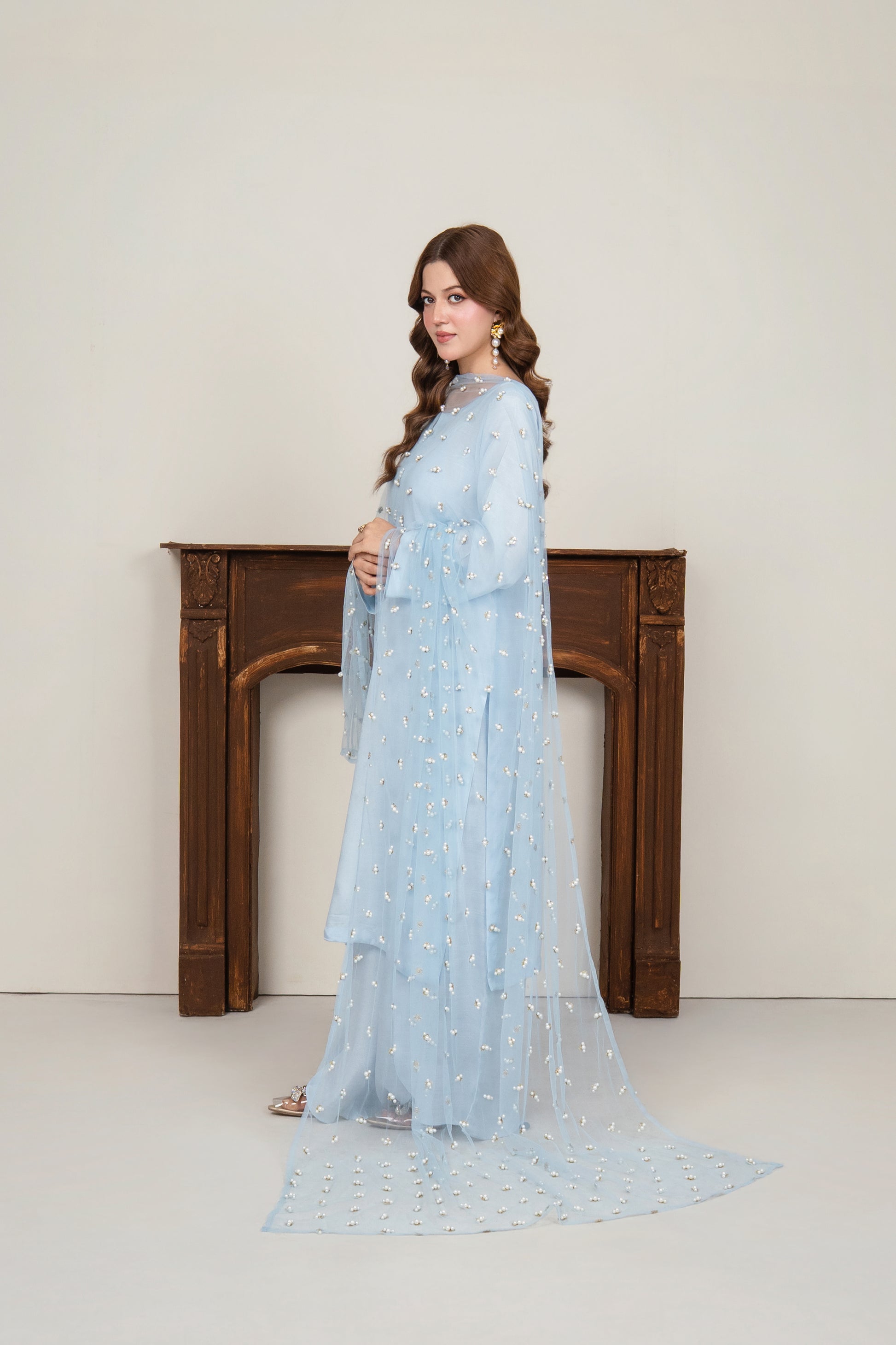 side view of the ice blue long flowy kurta, highlighting the graceful silhouette of the wrap-style petal pants in raw silk.