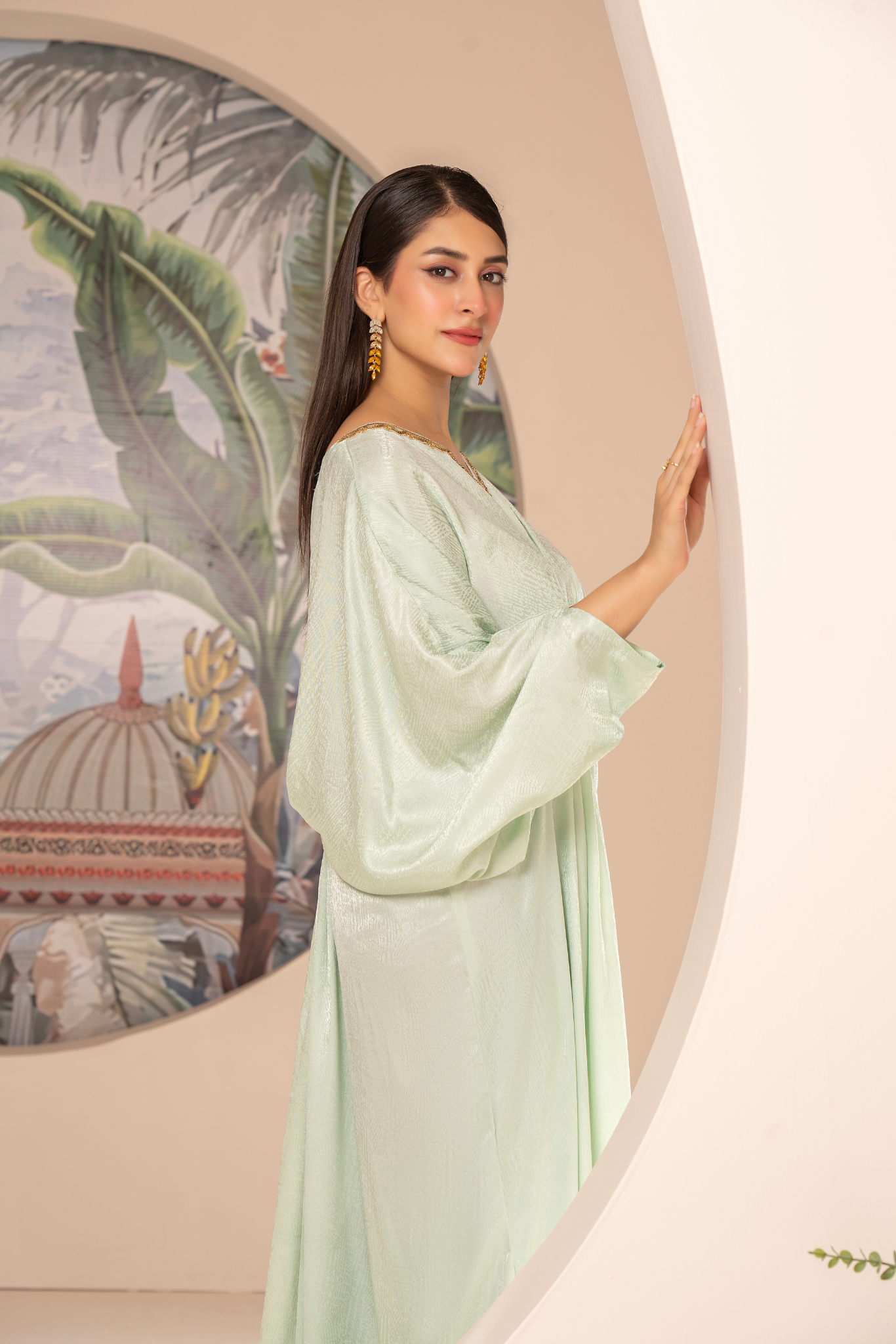 Elegant mint-green long dress from the Kanza Collection, featuring a draped silhouette with intricate gold embellishments at the waist, perfect for semi-formal or formal events.