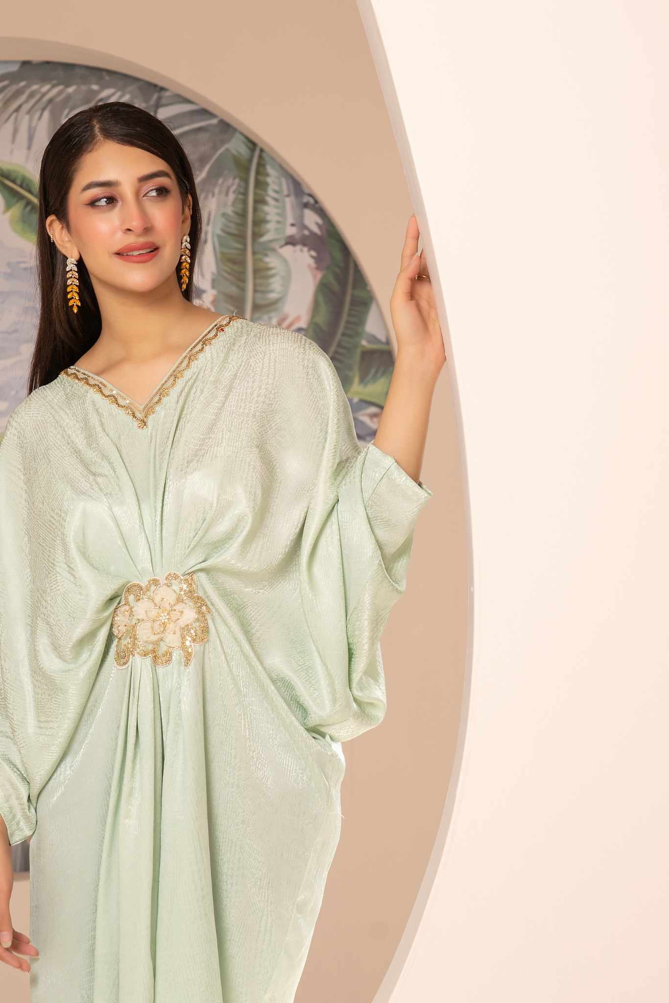 Elegant mint-green long dress from the Kanza Collection, featuring a draped silhouette with intricate gold embellishments at the waist, perfect for semi-formal or formal events.