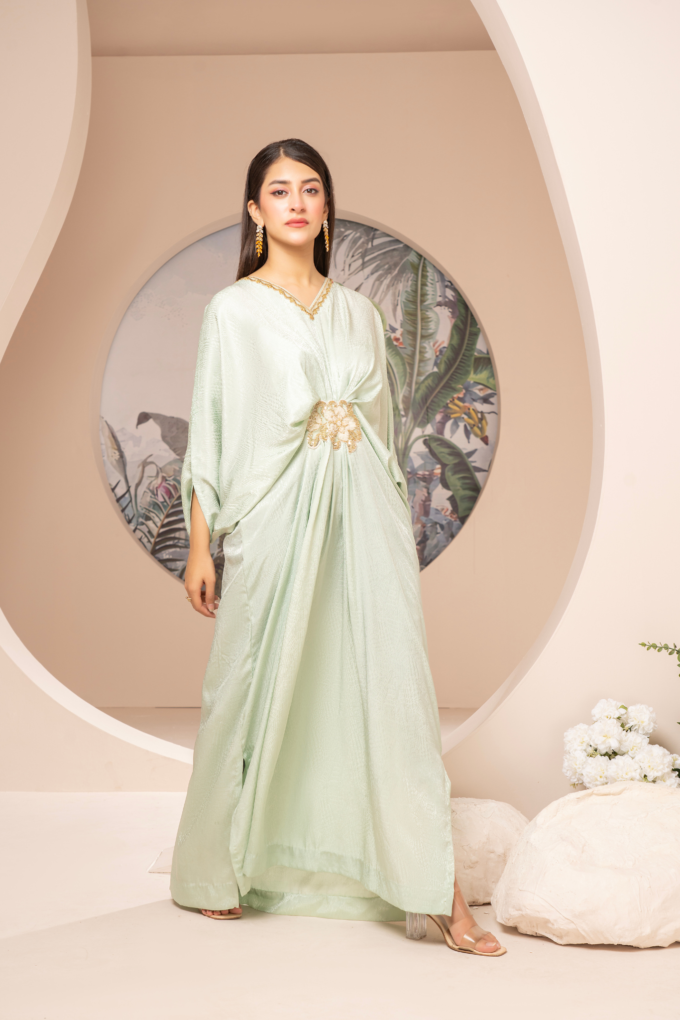 Elegant mint-green long dress from the Kanza Collection, featuring a draped silhouette with intricate gold embellishments at the waist, perfect for semi-formal or formal events.