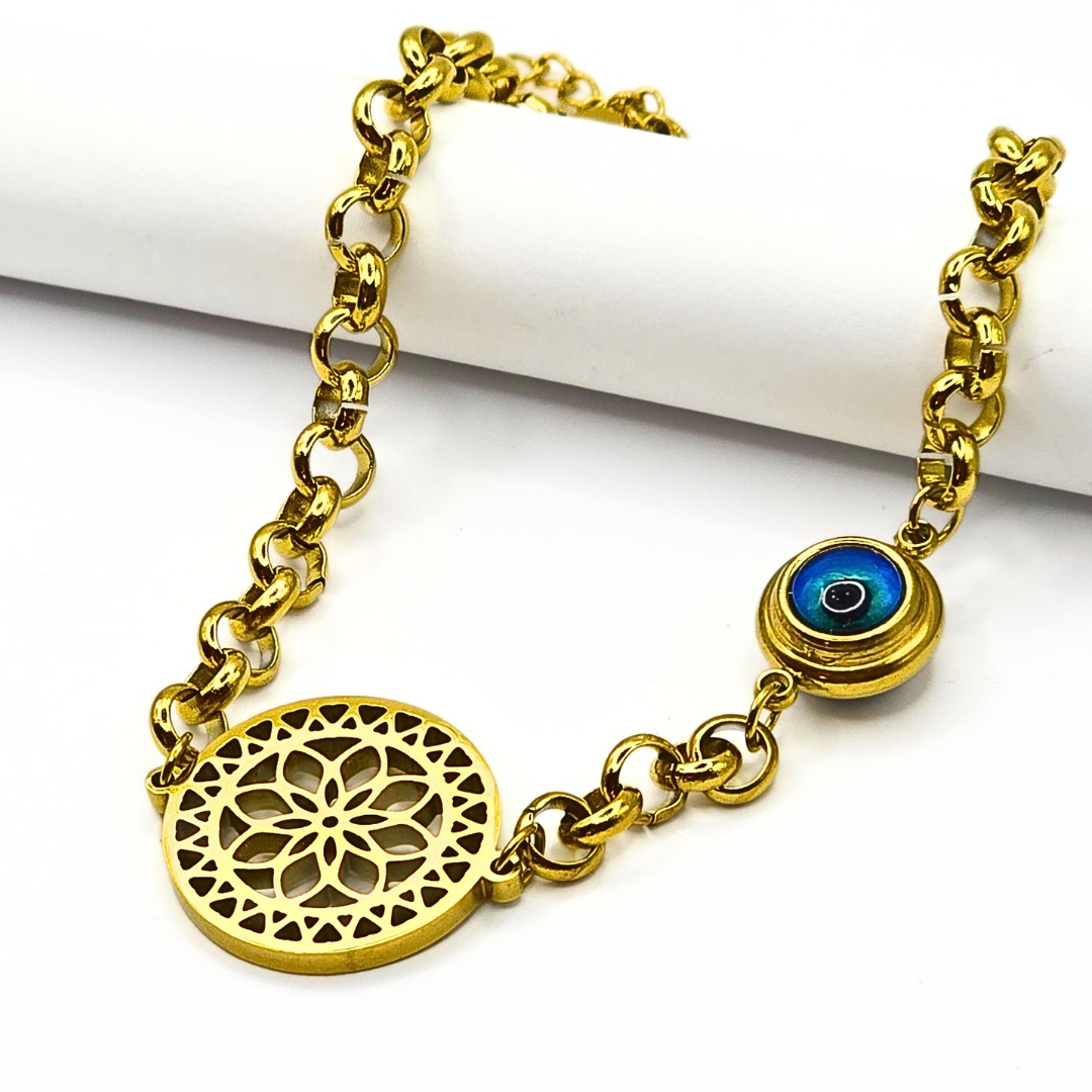 Gold-plated filigree bracelet with an evil eye charm, crafted from stainless steel with an adjustable link chain.
